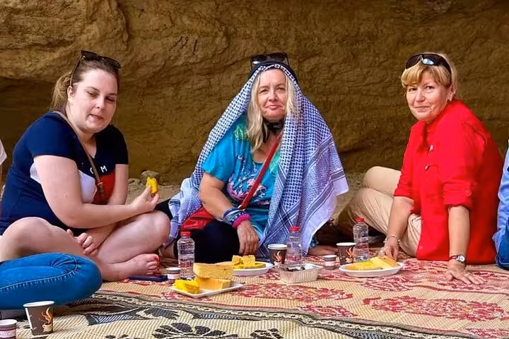 Tourists enjoying traditional picnic in a mountain cave during Fujairah Khorfakkan safari tour