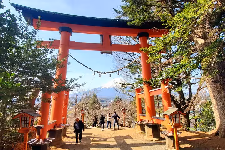 Red torii gate at Fuji Sengen Shrine with Mount Fuji backdrop on a 2-day Tokyo Mt Fuji Hakone guided tour