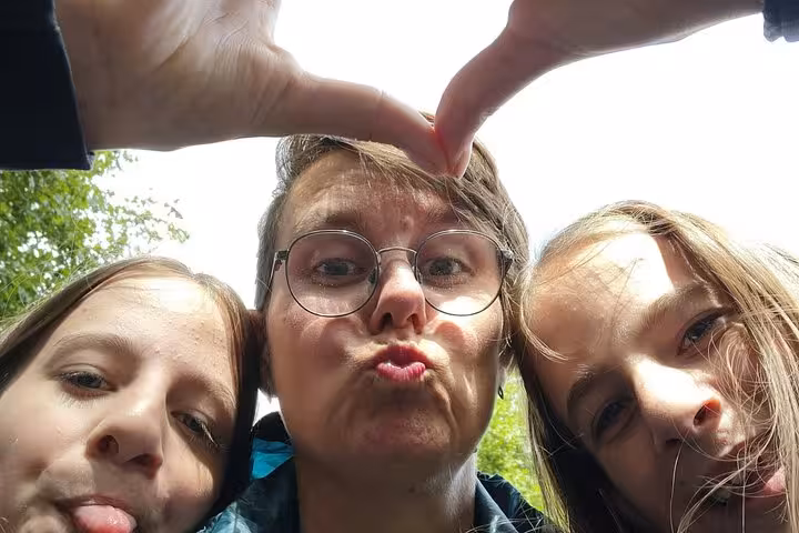 Three people making silly faces and heart hand gesture during a fun outdoor walking tour in Utrecht