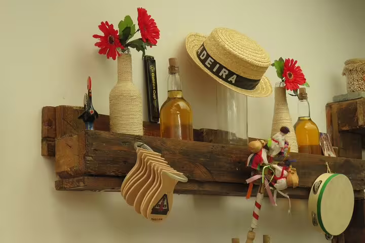 Rustic shelf display at a Funchal farmers market with Madeira straw hat, local wine, and vibrant decor, ideal for 4WD tour enthusiasts.