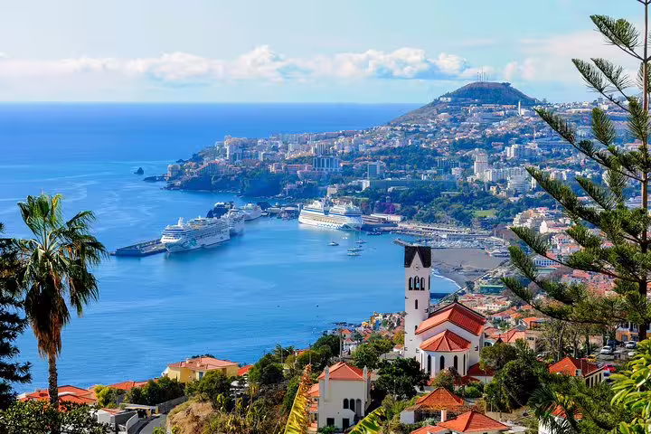 Panoramic view of Funchal's harbor and cityscape, a highlight of the full-day East of Madeira tour.