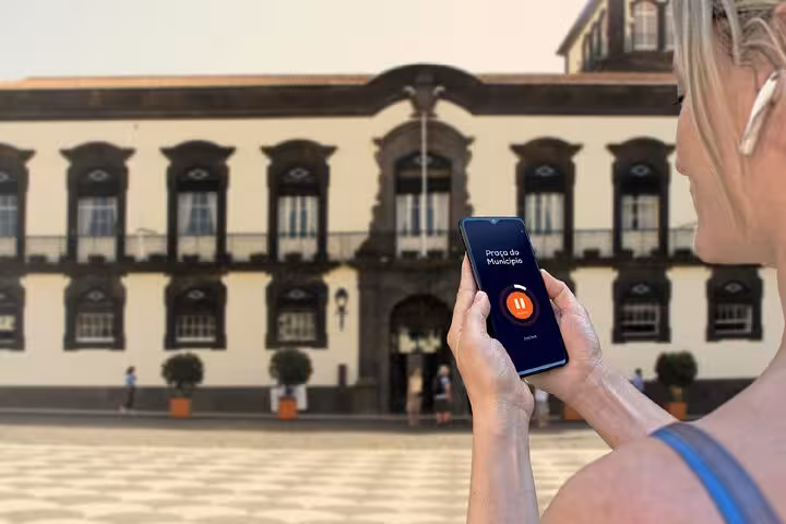 Tourist using audio guide app on smartphone at Praça do Município in Funchal, Madeira