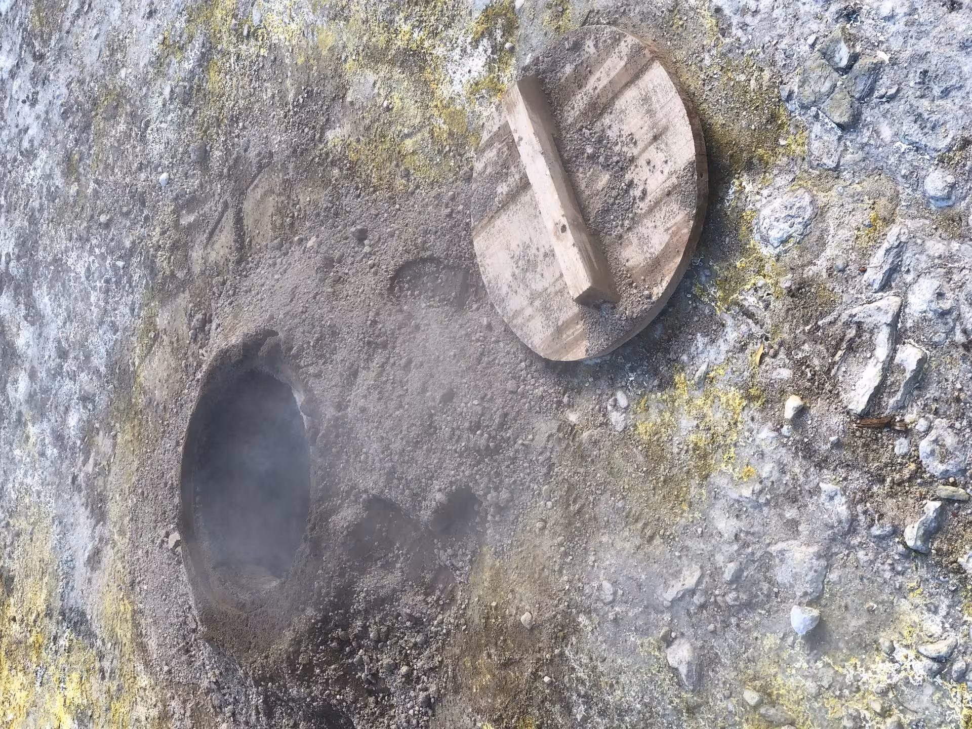 Steaming geothermal cooking pit and wooden lid in Furnas, São Miguel, showcasing traditional Azores cozido experience