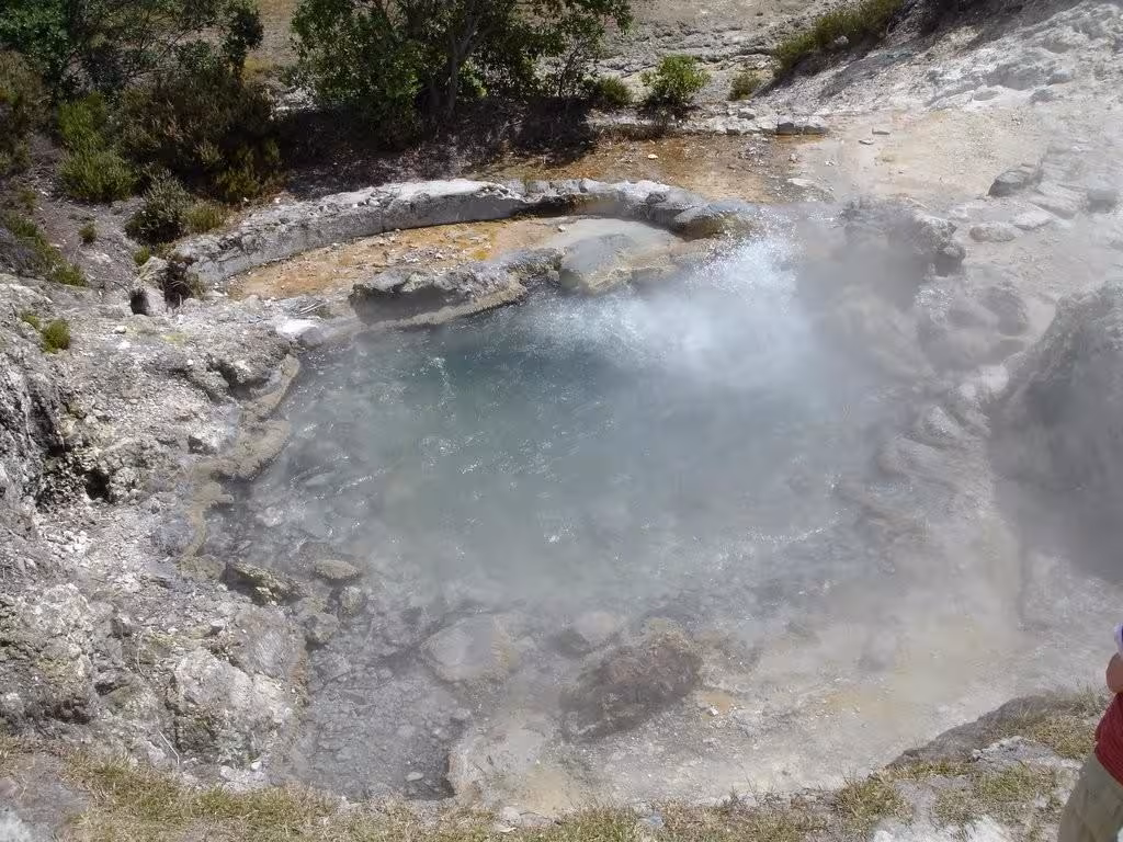 Close-up of a steaming geothermal hot spring pool surrounded by rocky terrain on a Half-Day Jeep Tour to Furnas, São Miguel