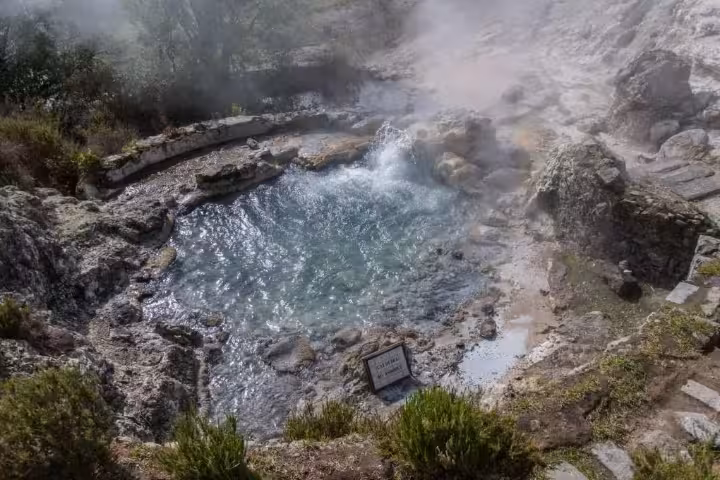 Bubbling Furnas hot spring pool surrounded by rocks and steam on a scenic Azores geothermal Jeep tour stop