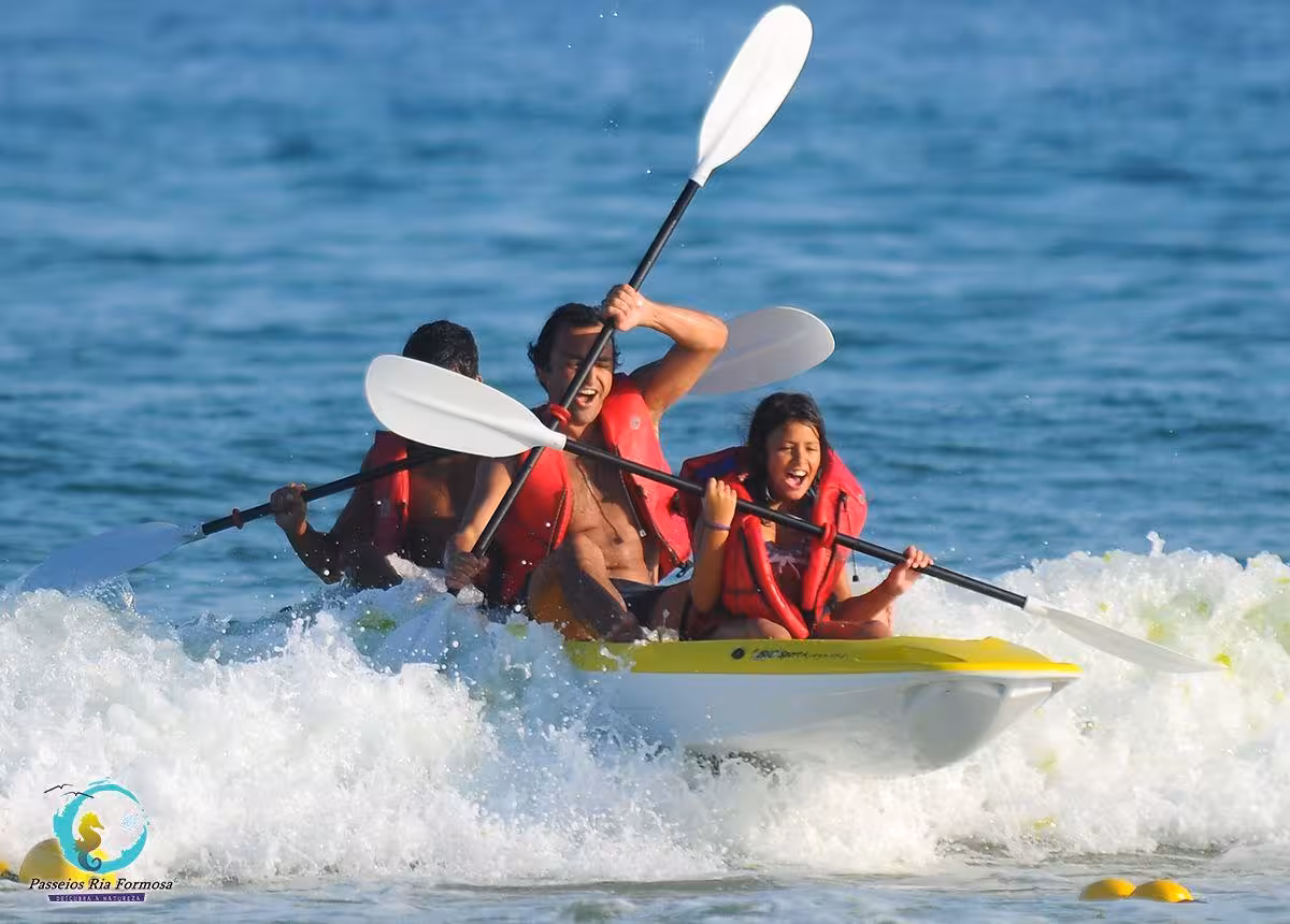 Family kayaking adventure in Fuzeta, Algarve, paddling a sea kayak through waves on the Atlantic coast