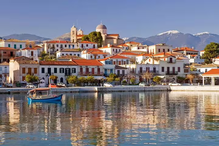 Galaxidi harbor with red-roofed houses reflected on calm sea, scenic stop on Delphi Itea private tour