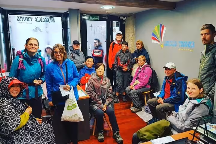 Tourists gathered inside a cozy Galician travel agency, preparing for the Costa da Morte excursion.