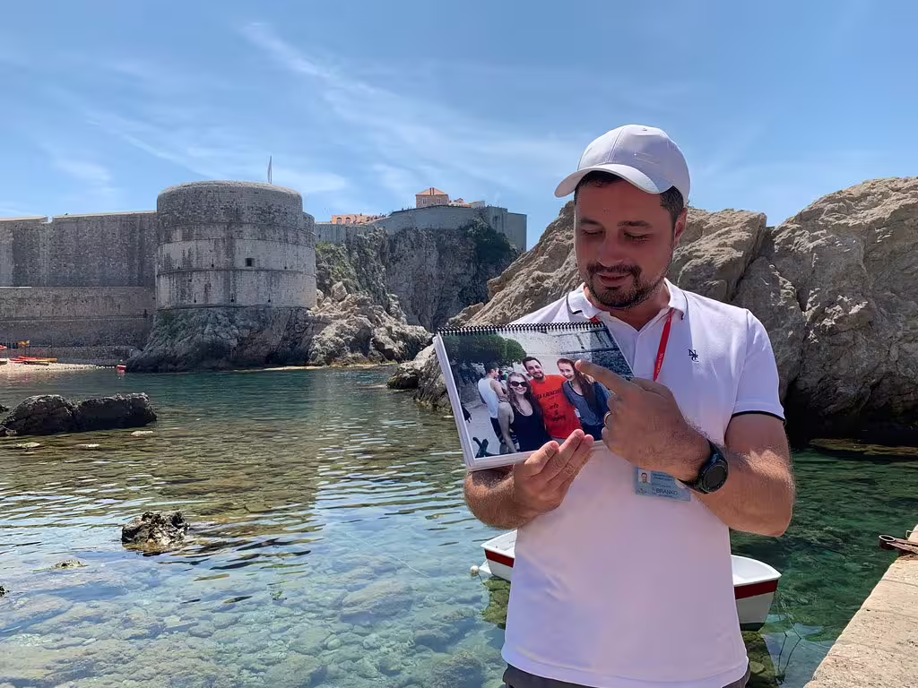 Local guide at Dubrovnik fort showing filming photo on Game of Thrones walking tour in King’s Landing