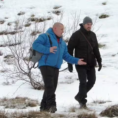 Two men hiking through snowy landscape at Lake Myvatn Iceland Game of Thrones tour
