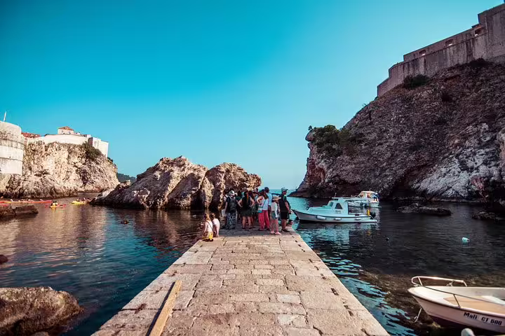 Group on a stone pier in Dubrovnik harbor on a Game of Thrones walking tour near King’s Landing locations