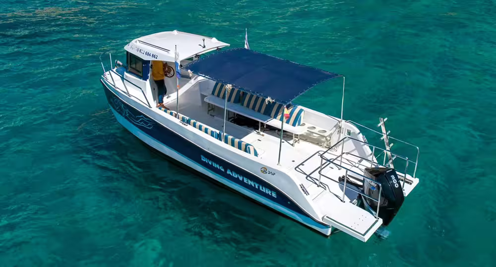Dive boat on crystal-clear waters of Garajau Marine Reserve, offering an unforgettable two-dive adventure trip.