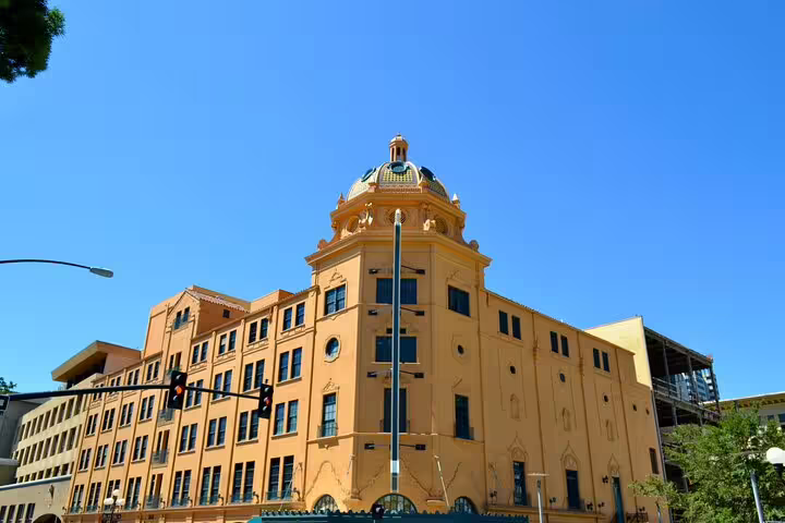 Historic yellow domed building with ornate architecture in San Diego's Gaslamp Quarter under blue sky