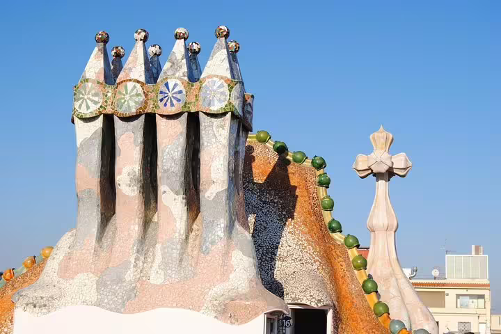 Explore the unique rooftop chimneys of Gaudi's Casa Batlló, showcasing vibrant mosaics and architectural whimsy in Barcelona.