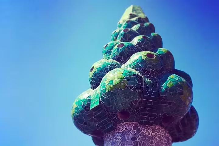 Mosaic-covered chimney detail from Gaudi's Casa Vicens, showcasing vibrant green tiles against a clear blue sky on a private tour.