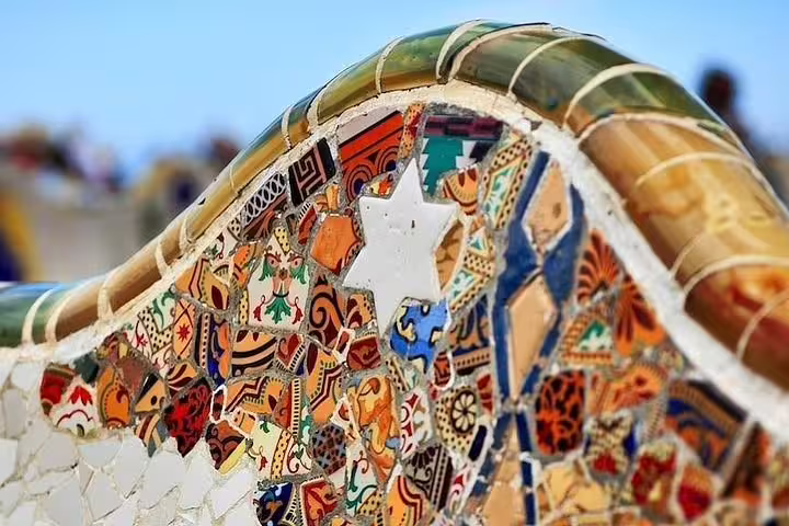 Close-up of vibrant Gaudí mosaic bench in Park Güell, showcasing iconic Barcelona artistry and architecture.