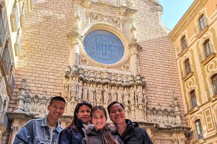 Family enjoying a 2-day tour at Montserrat Monastery, featuring breathtaking architecture on Gaudi & Sagrada Familia tour.
