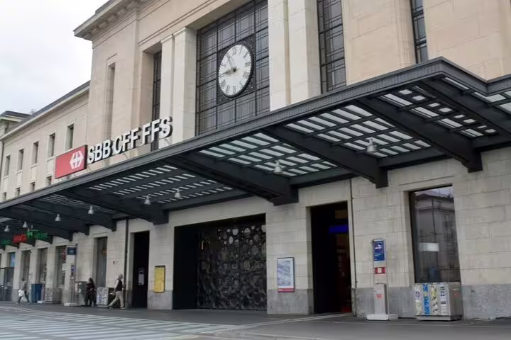 Geneva Cornavin train station entrance with SBB CFF FFS sign and clock above modern canopy