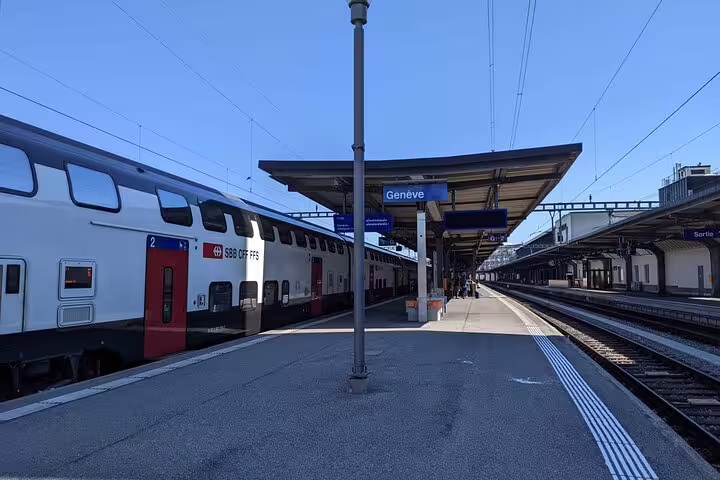 SBB double-decker train at Geneva Cornavin station platform under clear blue sky