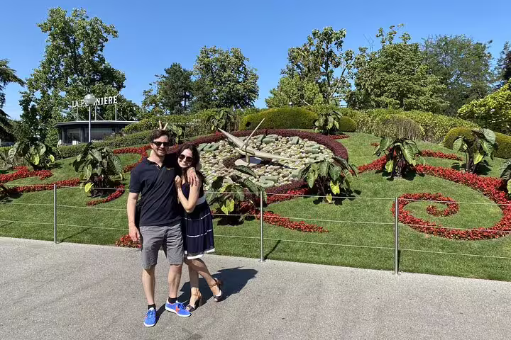 Couple posing in front of Geneva's famous flower clock at Jardin Anglais on a sunny day