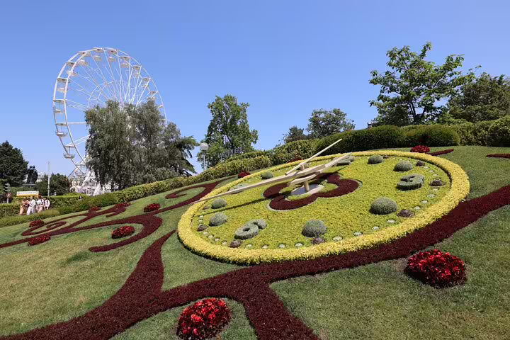 Flower clock garden with Ferris wheel in Geneva park on sunny day