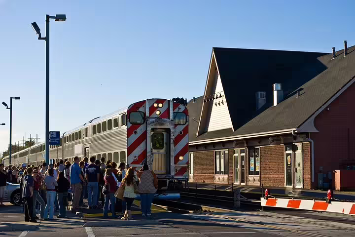 Crowd of passengers boarding a commuter train at a brick railway station platform