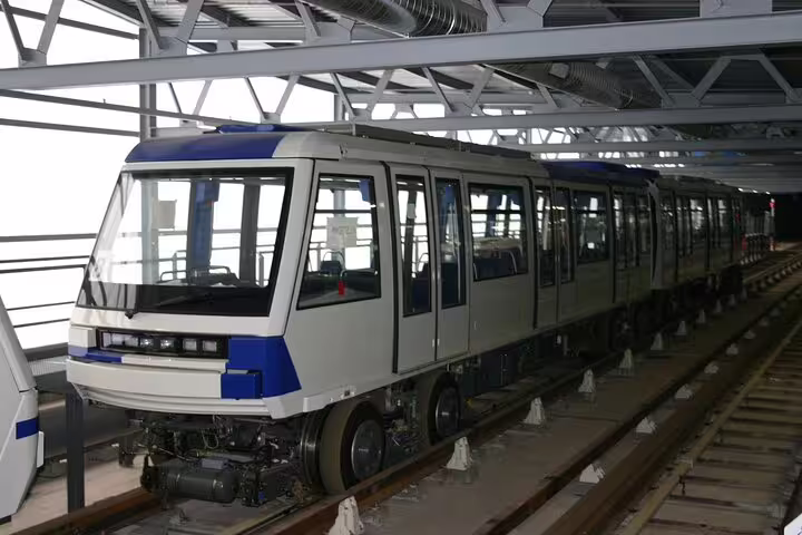 Modern blue and white metro train on elevated track in Geneva Switzerland