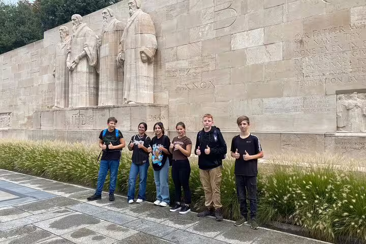 Group at Geneva Reformation Wall during a city highlights scavenger hunt walking activity with team challenges