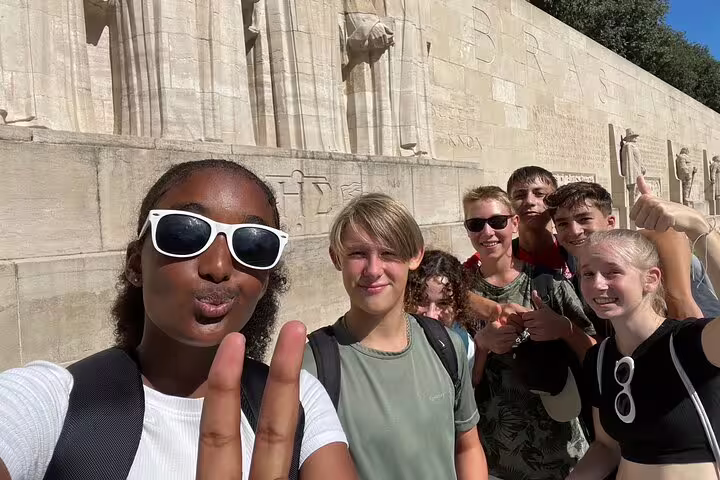 Friends take a selfie at Geneva Reformation Wall during a scavenger hunt city highlights walking tour