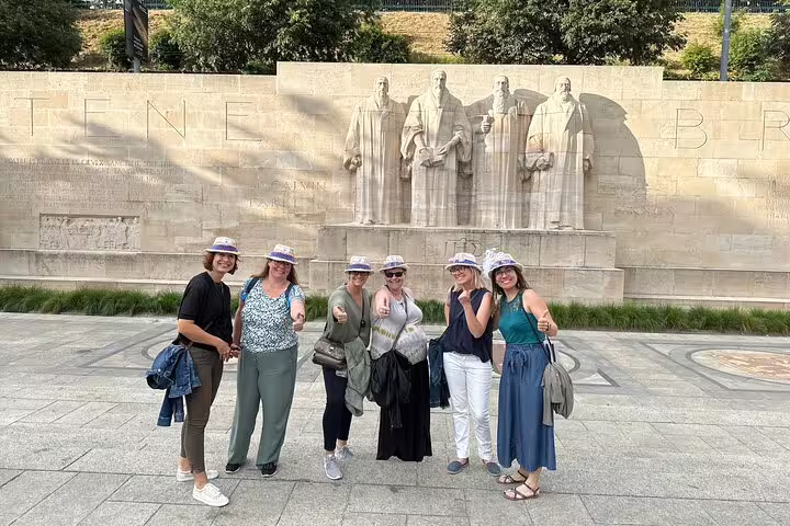 Friends pose at Geneva Reformation Wall during a scavenger hunt city highlights walking tour activity