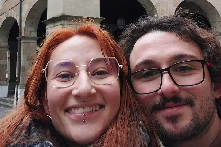 Two smiling tourists wearing glasses posing for selfie during Geneva walking tour