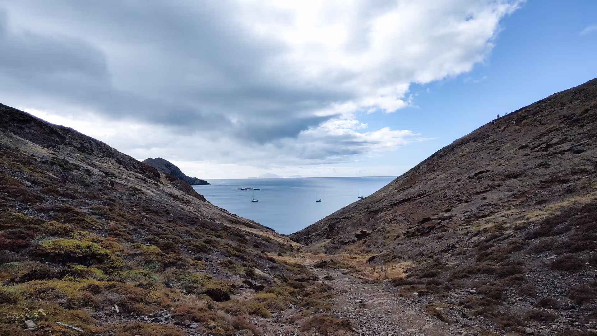 Panoramic view of serene bay surrounded by rugged hills on The Geological Hike, a must-visit for hikers.