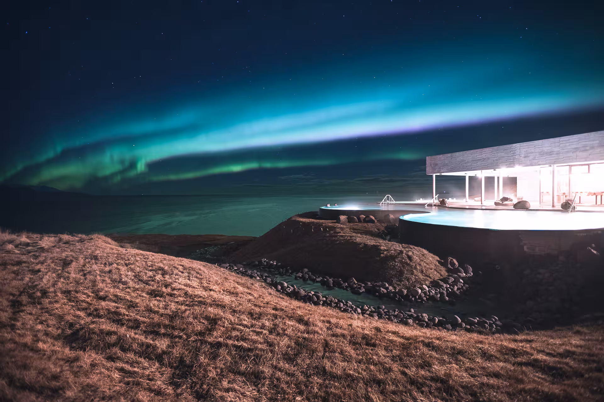 GeoSea Geothermal Baths illuminated under the vibrant Northern Lights in Iceland.