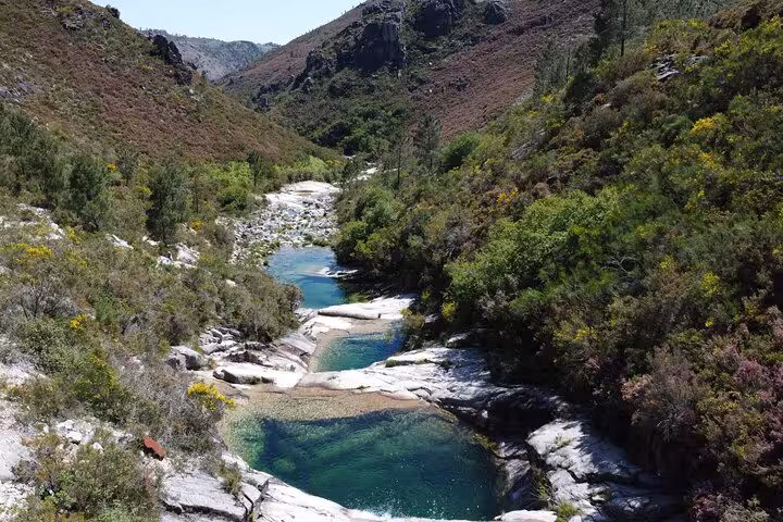 Scenic view of cascading lagoons surrounded by lush greenery in Geres National Park, ideal for nature walks and baths.