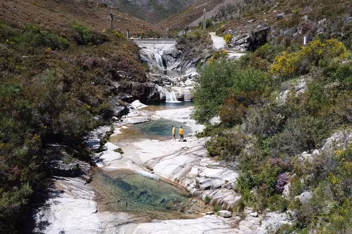 Picturesque view of cascading waterfalls and crystal-clear lagoons in Geres National Park, perfect for a refreshing swim.