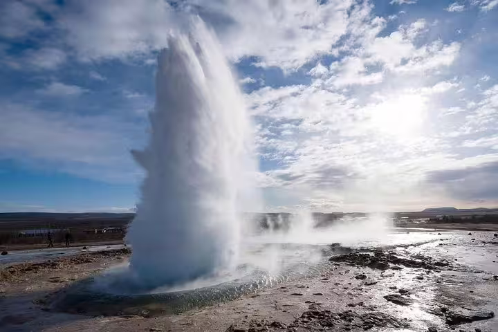 Powerful geyser eruption shooting hot water into cloudy sky in South Iceland
