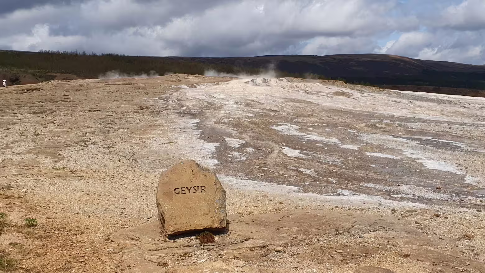 Geysir marker stone with steaming geothermal vents on Iceland's Golden Circle tour