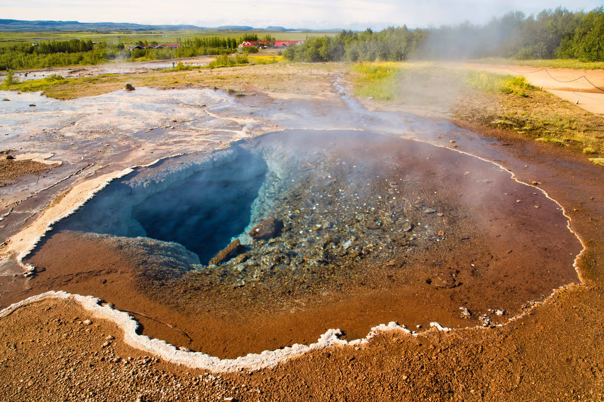 Steaming geothermal hot spring pool with vivid blue water at Geysir, Iceland Golden Circle