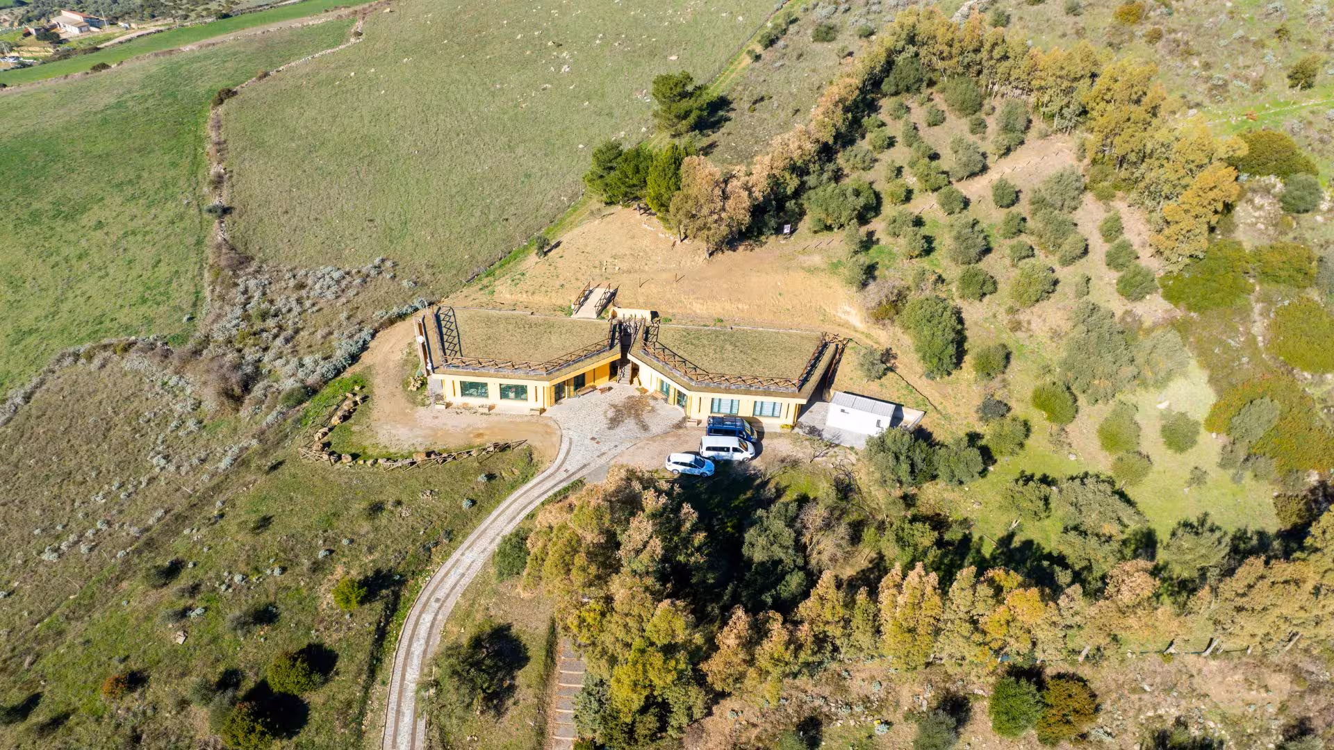 Aerial view of a modern building surrounded by greenery in Giara Park, showcasing sustainable architecture.