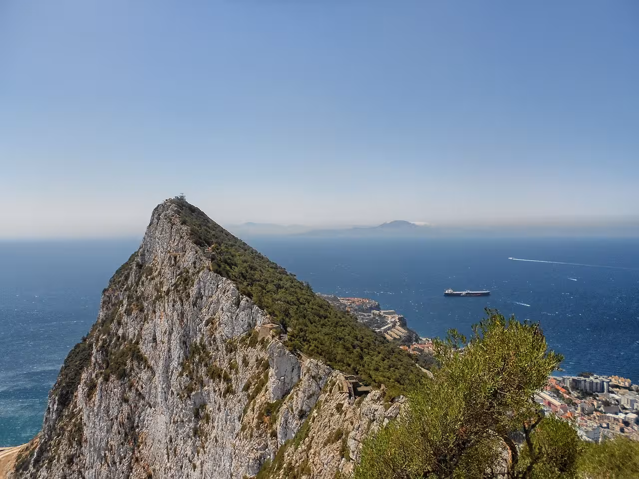 Stunning panoramic view from the top of the Rock of Gibraltar overlooking the blue Mediterranean Sea and Morocco coastline on a Gibraltar day trip.