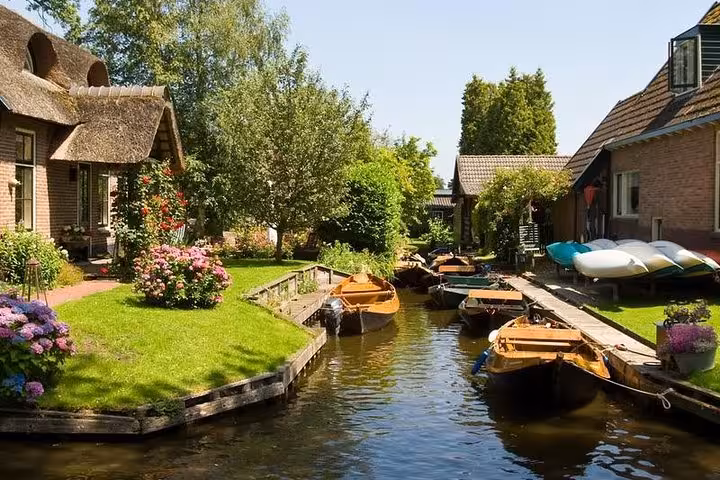 Giethoorn canal lined with cottages and moored boats, scenic Netherlands private tour with boat cruise