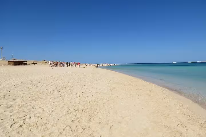 Wide sandy shoreline at Giftun Island National Park with calm Red Sea waters, ideal for snorkeling day tour