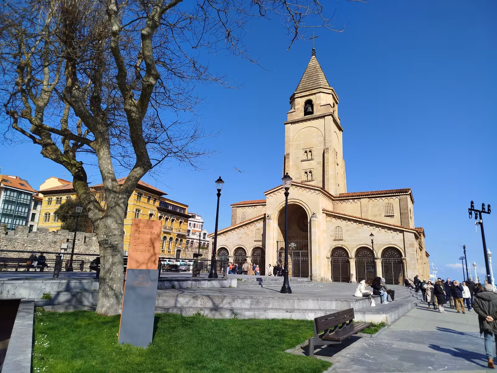 Discover Gijon's charming plaza and historic church tower on a vibrant city bus tour experience.