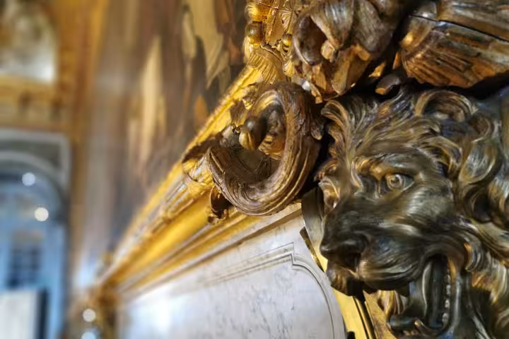 Close-up of gilded lion sculpture and gold detailing inside Versailles Palace on skip-the-line guided tour