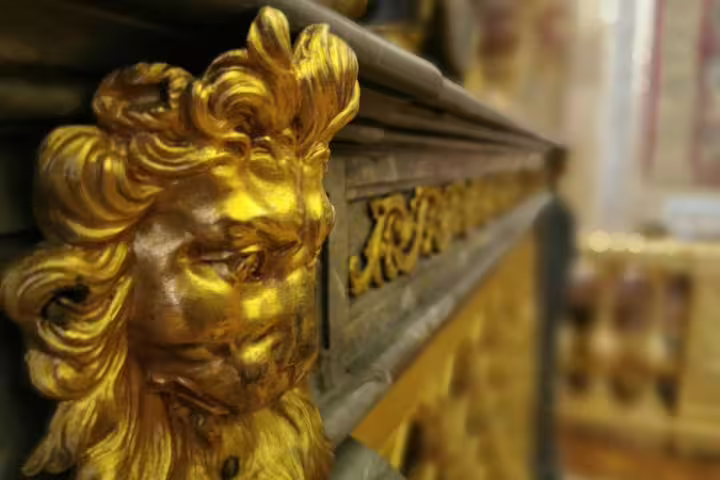 Close-up of gilded lion decor in Versailles Palace interior on private guided day tour from Paris