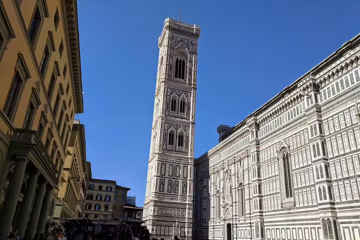 Giotto's Campanile bell tower and Florence Cathedral facade under clear blue sky