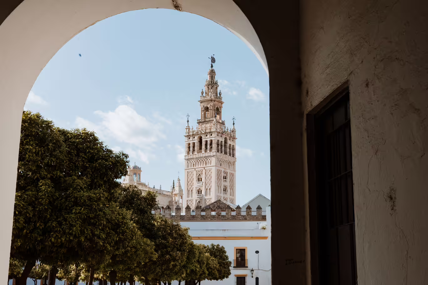 View of the iconic Giralda Tower framed by an archway, a key site in Seville's Santa Cruz Jewish Quarter tour.