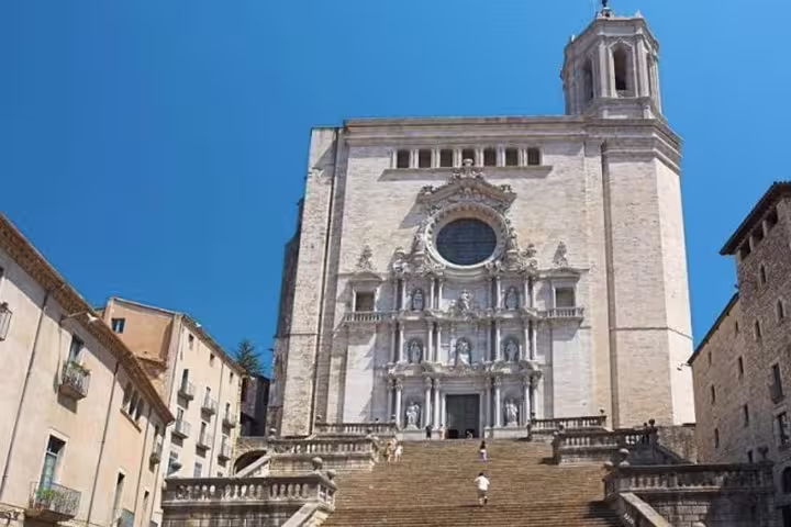 Impressive steps lead to Girona Cathedral's ornate facade under a clear blue sky, a highlight of the Costa Brava tour.