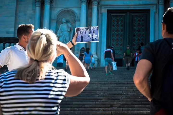 Visitors admire the famous Girona Cathedral steps with a film location photo, highlighting cultural and historic tourism.