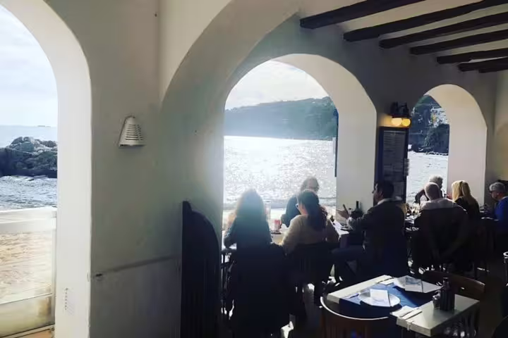 Seaside restaurant with arched windows offering stunning views of the Costa Brava coastline during a Girona tour.